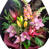 A vibrant bouquet of multi-colored flowers including orange, yellow, green, pink, flowers, arranged in a oval shape.