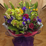 Bouquet of flowers with green, purple, and red colors arranged in a water-box