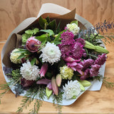 a stunning bouquet of chrysanthemum, oriental lilies and lush foliage wrapped in natural and white craft paper.