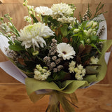 a mixed bouquet of white flowers and green foliage.