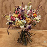 A mixed dried bouquet, consisting of dahlia, amaranth, red roses, protea, strawflowers and solidago