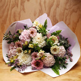 Bouquet of pink and white summer flowers wrapped in heavy white paper