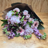 Bouquet of pink and purple flowers on a wooden surface