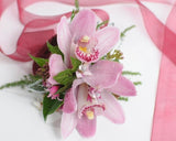 Pink orchid wrist corsage with diamantes and silver accent leaves