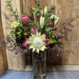 Bouquet of flowers in a clear vase against a wooden background
