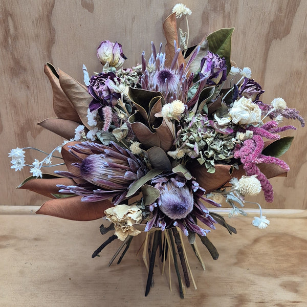 Bouquet of dried flowers with purple and white tones on a wooden surface