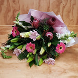 pink gerberas, standard mauve chrysanthemums, oriental lilies, snaps and protea in a bouquet