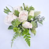 A pale pink rose wrist corsage with lime green accents