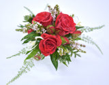 A wrist corsage with mini roses, fern and thryptomene.